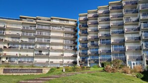 A multi-story residential building with balconies, a sign reading "L'artangrove," and a well-maintained lawn area. - Joli Studio Avec Grand Balcon vue mer (Concarneau)