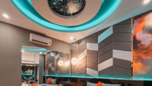 A modern bedroom with a large bed, a built-in TV, and a unique ceiling design. - Tan Binh Hotel (Ho Chi Minh City)