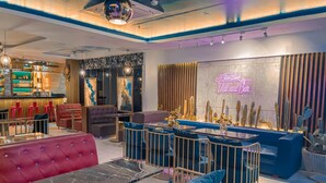 A modern lounge area with a bar, seating, and a neon sign. - Tan Binh Hotel (Ho Chi Minh City)