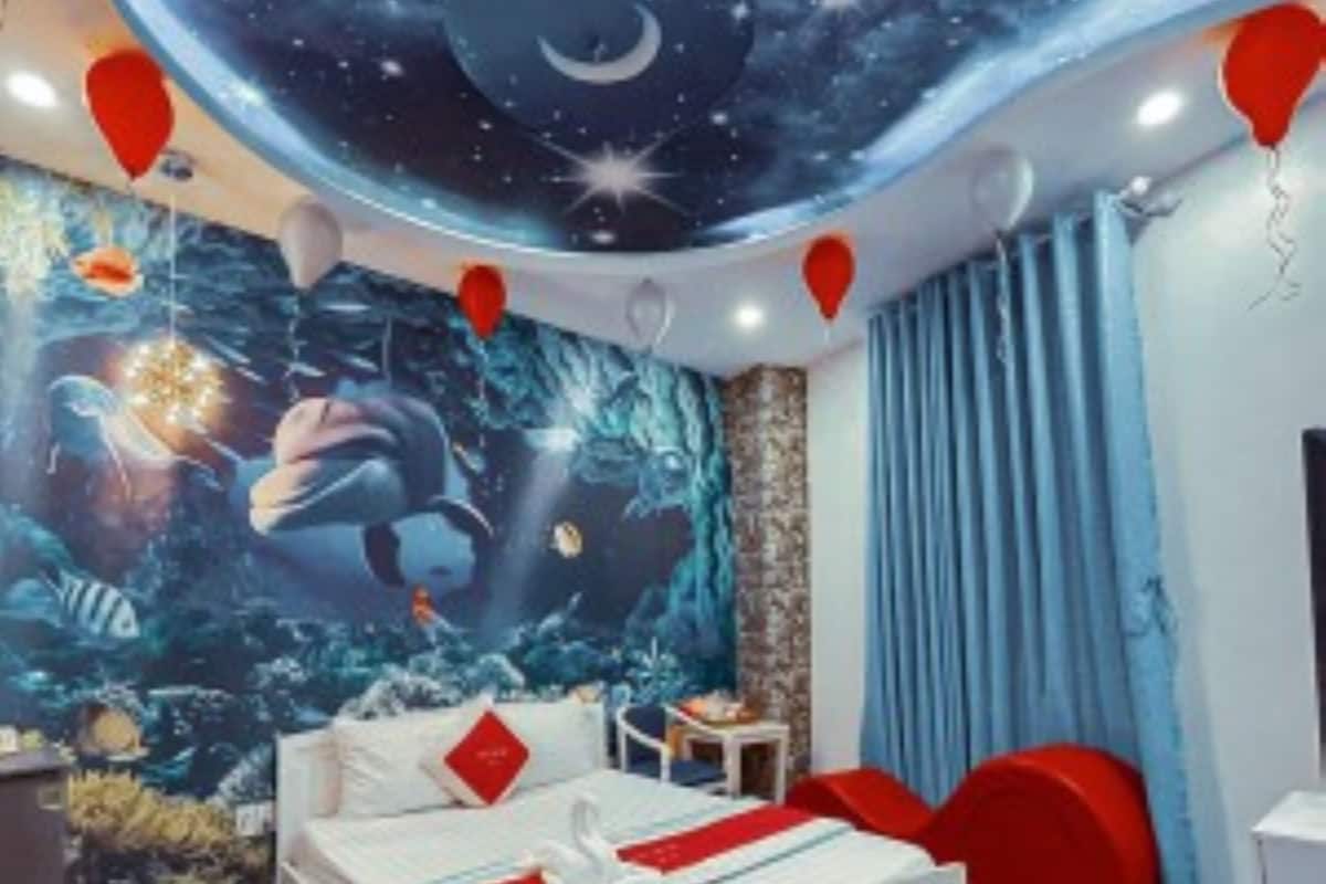 Een slaapkamer met een bed, een muurschildering van een nachthemel en rode ballonnen.
