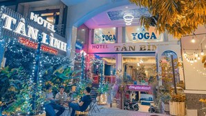 A hotel with a sign reading "HOTEL TÂN BÌNH" and a yoga studio with a similar sign. - Tan Binh Hotel (Ho Chi Minh City)