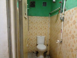 A small, narrow bathroom with a toilet, a shower, and a sink. - Hotel Alifah 1 Syariah (Tangerang)
