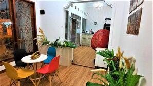 A modern living room with a dining area, wooden flooring, and a kitchen in the background. - Wisma Acidalia Syariah (Bandung)
