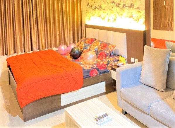 A modern bedroom with a bed, a sofa, and a nightstand.
