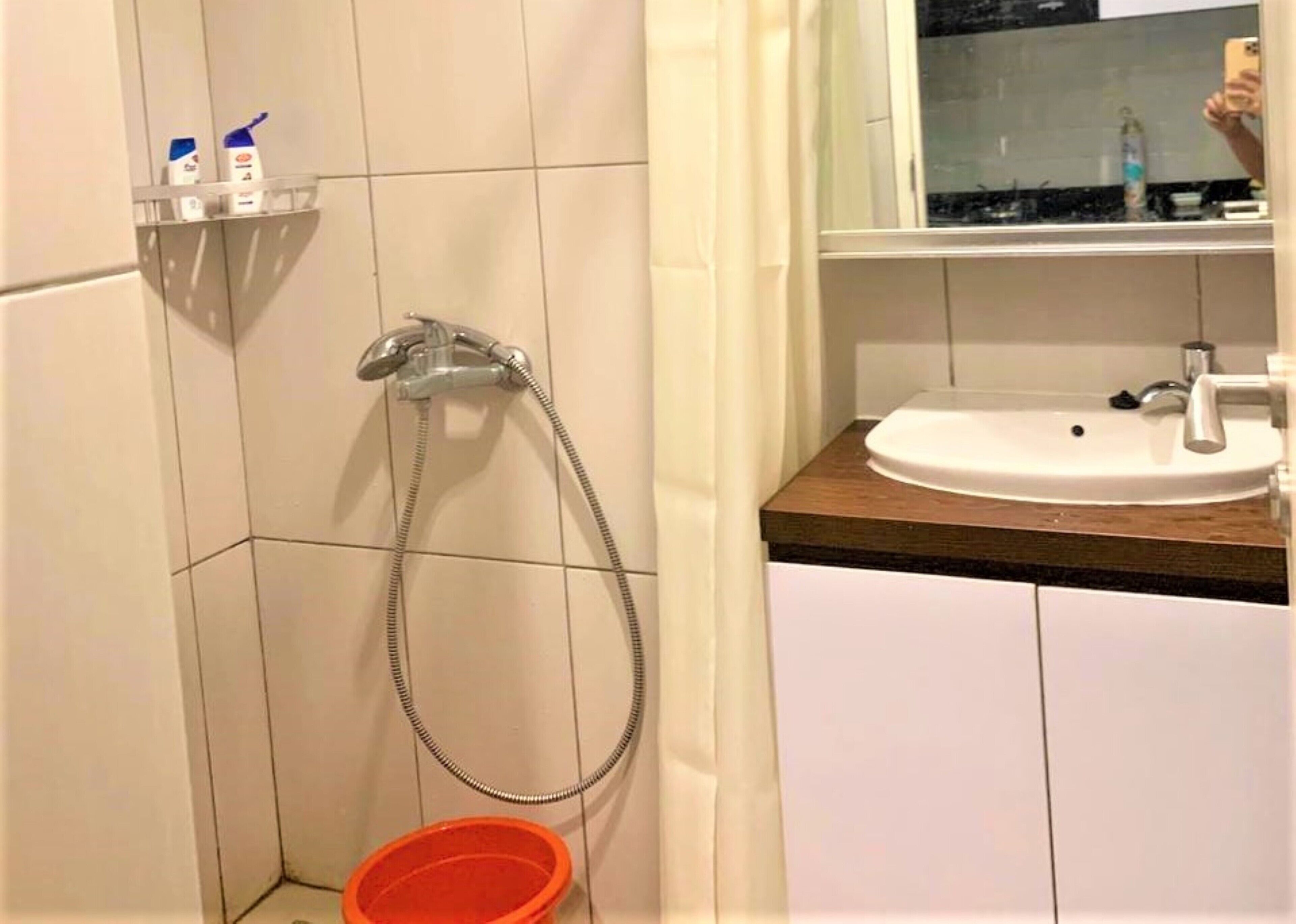 Un baño con ducha, lavabo y espejo.