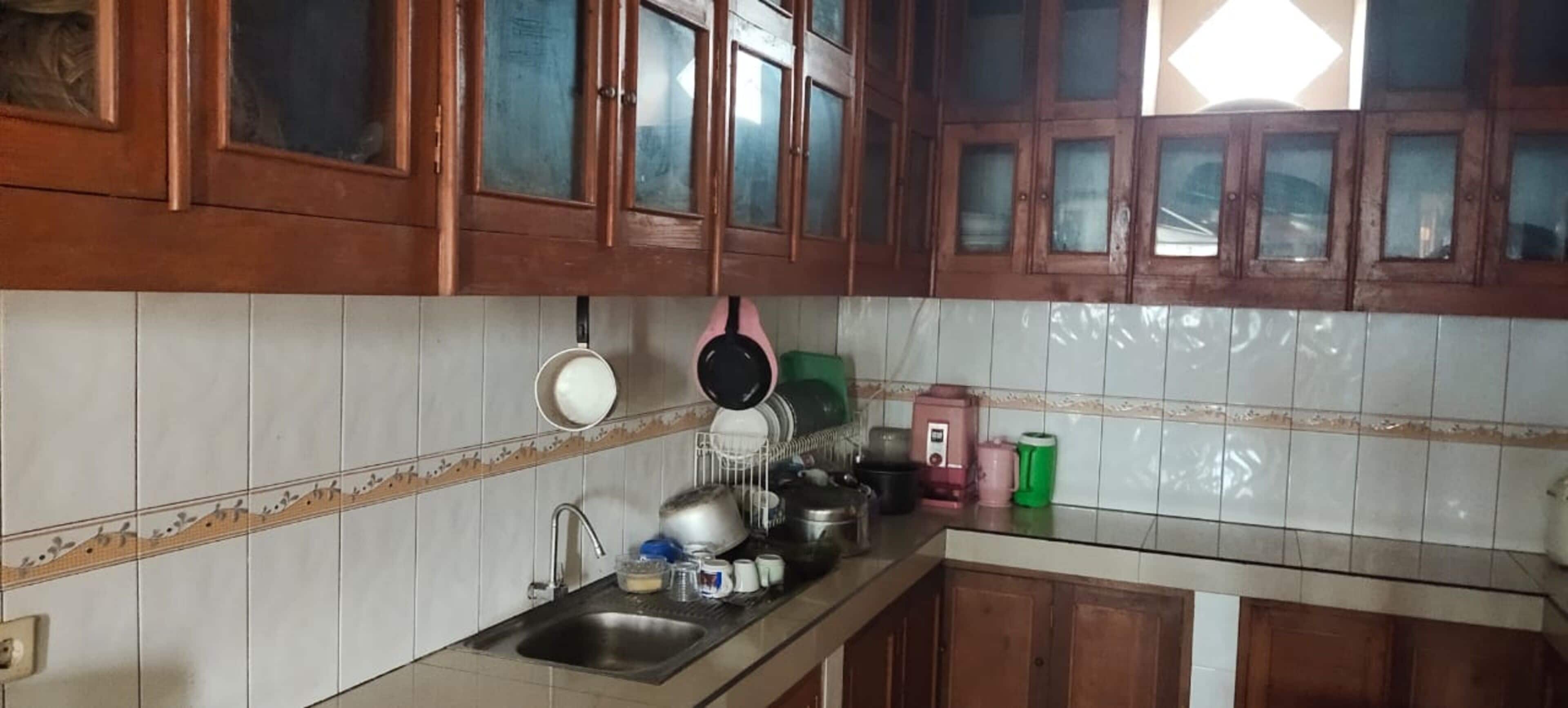 A kitchen with wooden cabinets, a stainless steel sink, and various kitchen appliances.