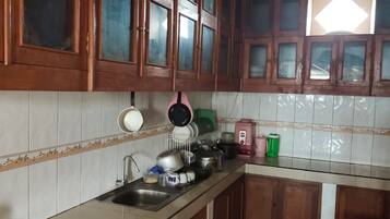A kitchen with wooden cabinets, a stainless steel sink, and various kitchen appliances.