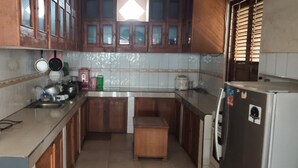 Una cocina con armarios de madera, una encimera, un fregadero y un refrigerador.