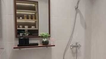 Un bagno moderno con lavabo incassato, specchio e doccia.