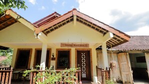 Perinteinen rakennus, jonka yläpuolella on kyltti, jossa lukee: ”Homestay Slonzt Ubud”.