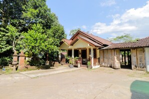 Set amidst lush greenery, this two-story house offers a serene retreat with a porch and garden area.