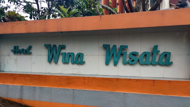 A sign for "Hotel Wna Wisata" with a white background and teal lettering. - Hotel Wina Wisata (Bandungan)