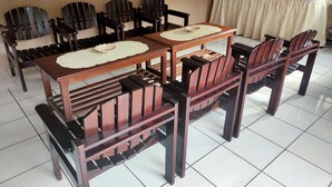 A dining area with a rectangular table and six wooden chairs. - Hotel Wina Wisata (Bandungan)