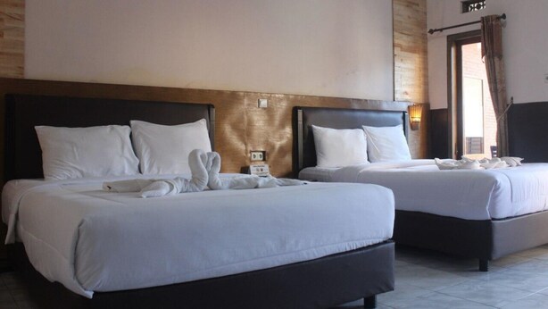 A hotel room with two beds, each with white linens and a dark headboard. - Rahayu Jawarika Bromo Hotel (Ngadisari)