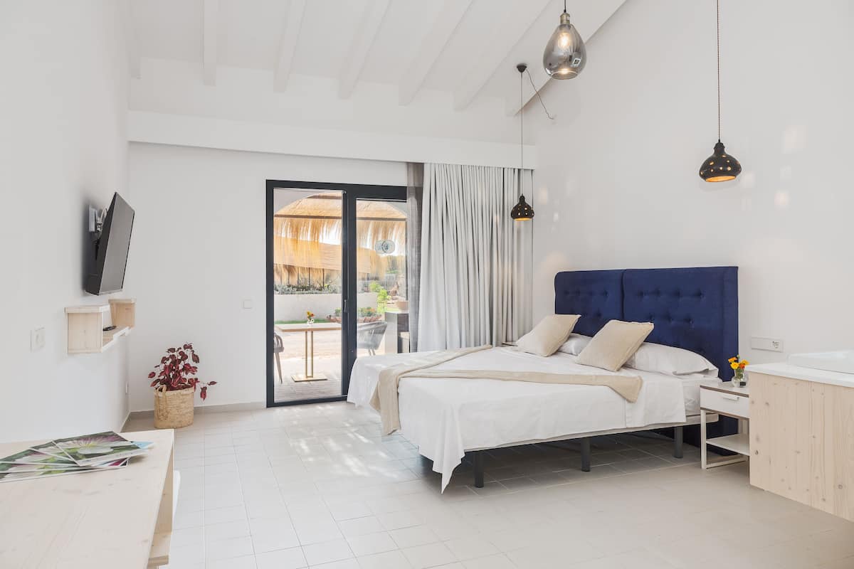 Une chambre à coucher moderne avec un lit, une table de chevet et un téléviseur fixé au mur.