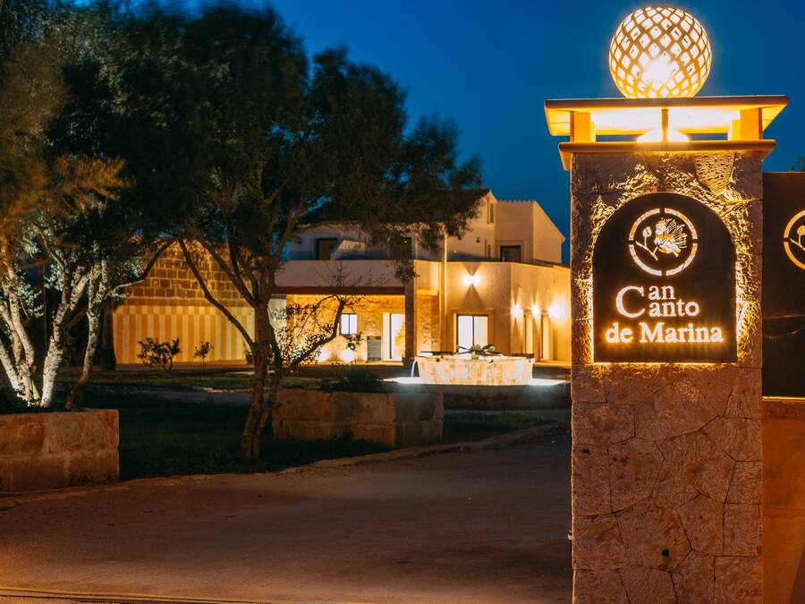 A stone entrance with a sign reading "Canto de Marina" and a decorative sphere above it.