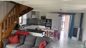 A modern kitchen with white cabinets, a black countertop, and a built-in oven. - Villa 6 pl 400 m from the sea (Cléder)