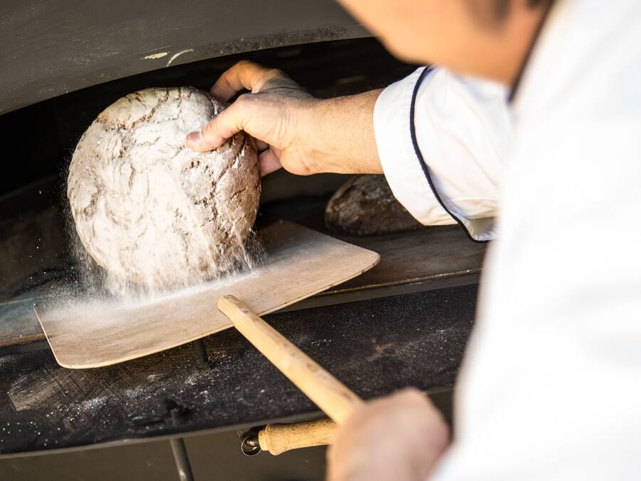 Una persona sosteniendo un pan en una panadería.