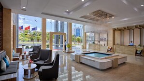 Un'ampia hall con reception, area relax e piscina.
