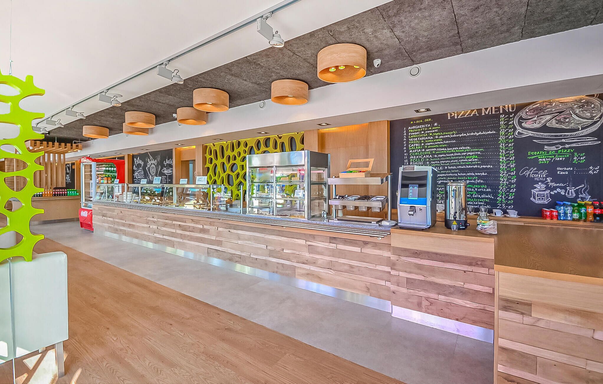 Een modern café met een houten toonbank, een koffieapparaat en een krijtbordmenu.