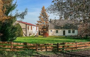 Escape to a serene rural retreat surrounded by lush greenery and mature trees.