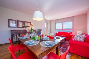 A dining area with a wooden table, red chairs, and a vase of flowers. - La Maison du Bonheur (Lugano)