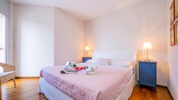 A neatly arranged bedroom with a bed, bedside tables, and a bench.