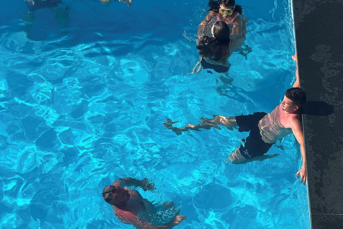 Une piscine à l’eau d’un bleu cristallin, entourée d’une terrasse carrelée.