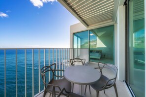 A balcony with a table and chairs overlooking the ocean. - Barreirinha Front-Line Sea View II (Funchal)