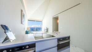 Una cucina moderna con un'isola grande, forno integrato e vista su un balcone.