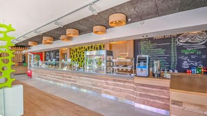 Un caffè moderno con un bancone in legno, una macchina per il caffè e una lavagna con il menu.