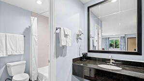 Un baño moderno con inodoro, ducha y lavamanos.