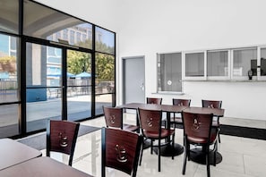 Un comedor moderno con amplios ventanales, interior blanco y vistas al exterior.