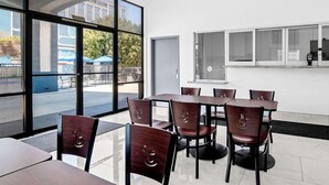 A modern indoor dining area with large windows, a white interior, and a view of the outside. - Surestay Hotel by Best Western Buena Park Anaheim (Buena Park)