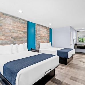 Ein modernes Hotelzimmer mit zwei Betten, einem Badezimmer und einer Küchenzeile.