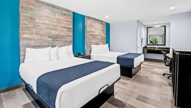 A hotel room with two beds, a desk, and a large mirror. - Surestay Hotel by Best Western Buena Park Anaheim (Buena Park)