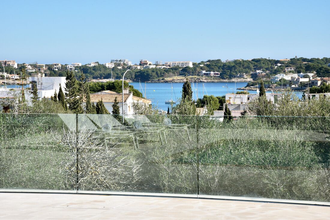 A coastal town with a clear view of the sea, buildings, and greenery.