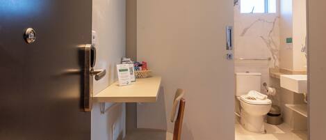 Une salle de bain moderne avec des toilettes, un lavabo et une petite fenêtre.