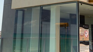 Fachada moderna de hotel con un amplio acceso de vidrio y un logotipo destacado.