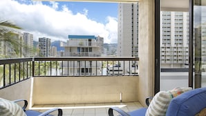 Een balkon met uitzicht op een stadsgezicht, inclusief wolkenkrabbers en een berg in de verte.