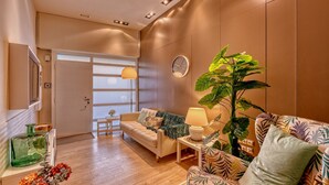 Una sala de estar moderna con un sofá, una mesa de centro, una planta grande y un reloj de pared.