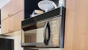 A kitchen with a black stove, a microwave, and a coffee maker on the counter. - Prime downtown location, luxury condo getaway  (Wilmington)