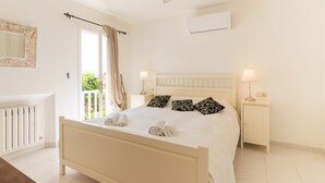 Una camera da letto con un letto, due comodini, una finestra con tende e un termosifone.