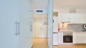 Una cucina moderna con mobili bianchi, forno integrato e microonde.