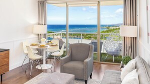 A modern living room with a balcony, a dining area, and a seating arrangement. - Ocean-City Views Glamorous Condo at The Watermark w/Parking & Full Kitchen (Honolulu)