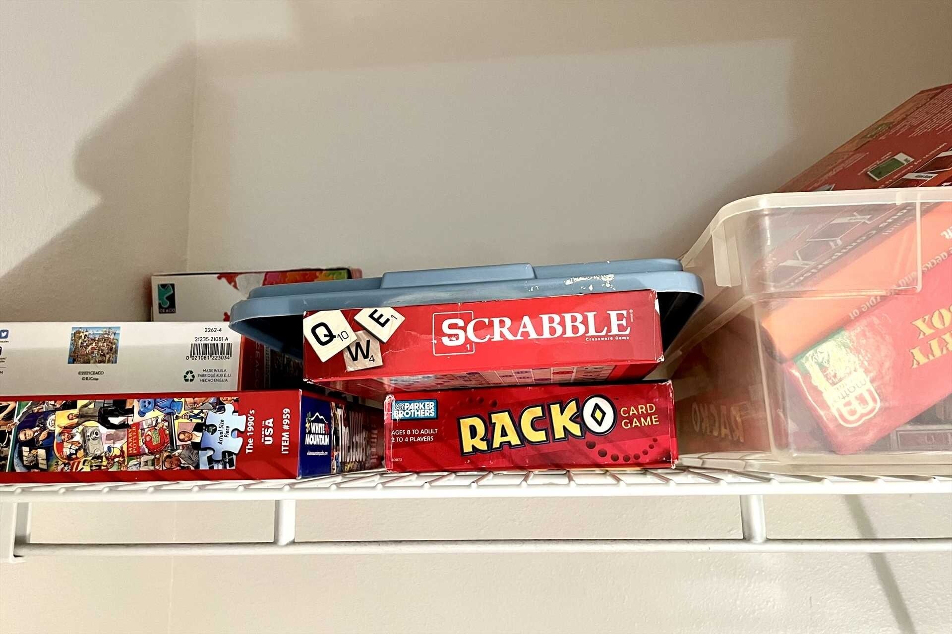 En hylla med brädspel, inklusive Scrabble, Raccoon och ett pusselspel.