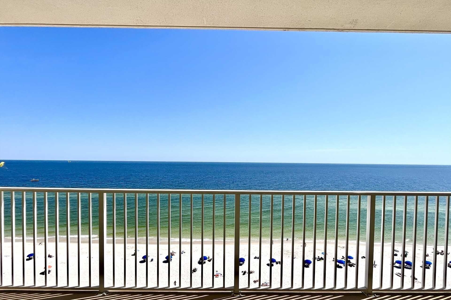 A balcony with a view of the beach and ocean.