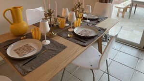 A dining table set with plates, cutlery, and candles.