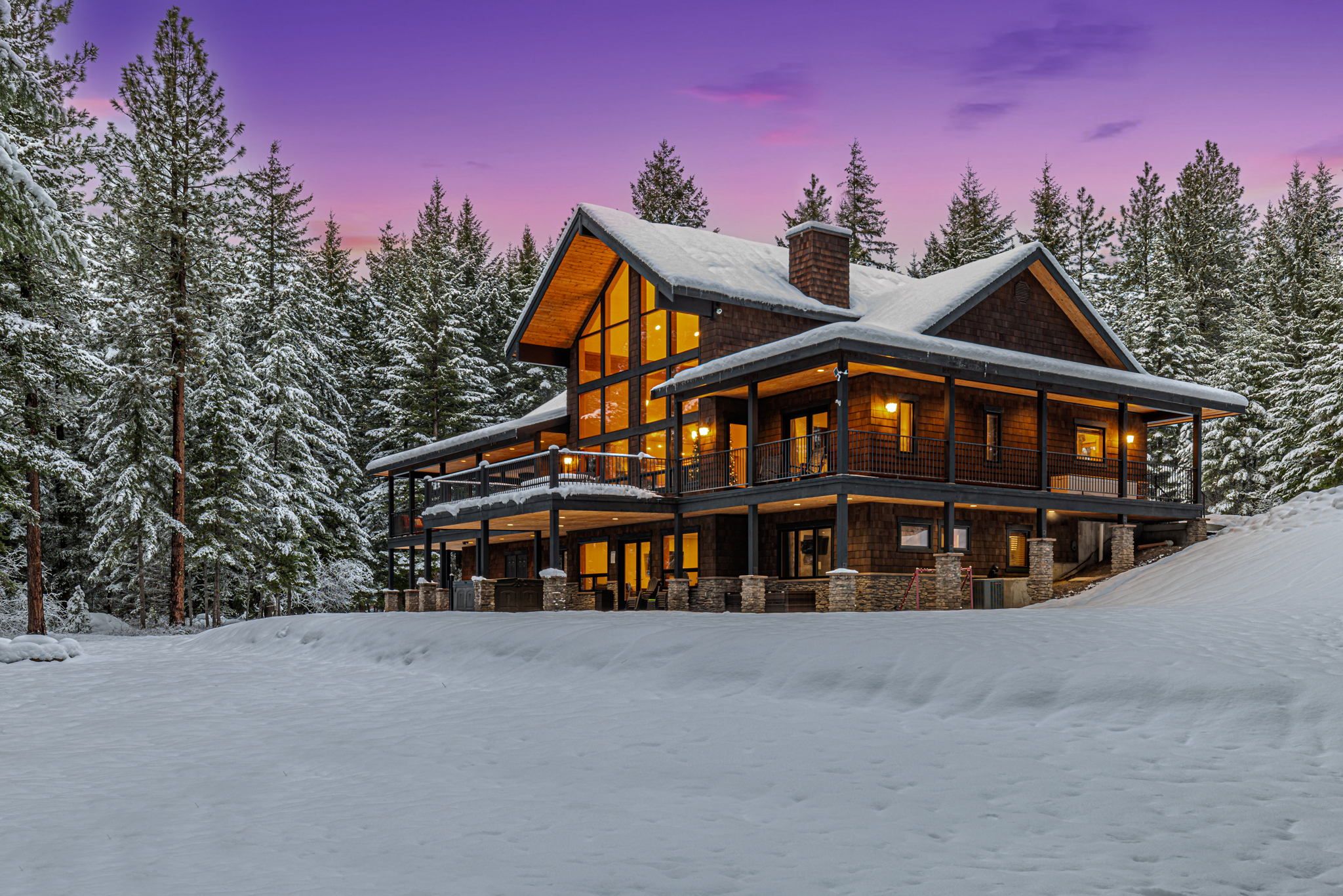 Winter Dusk – Lodge Lit Up Among Snow-Covered Pines + Wraparound Decks
