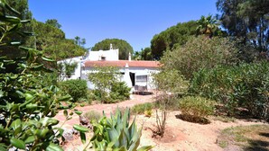 A white building with a red-tiled roof, surrounded by greenery and trees. - Fantastic outdoor area, private pool, Tennis Court & Golf Practice Facility (Faro)